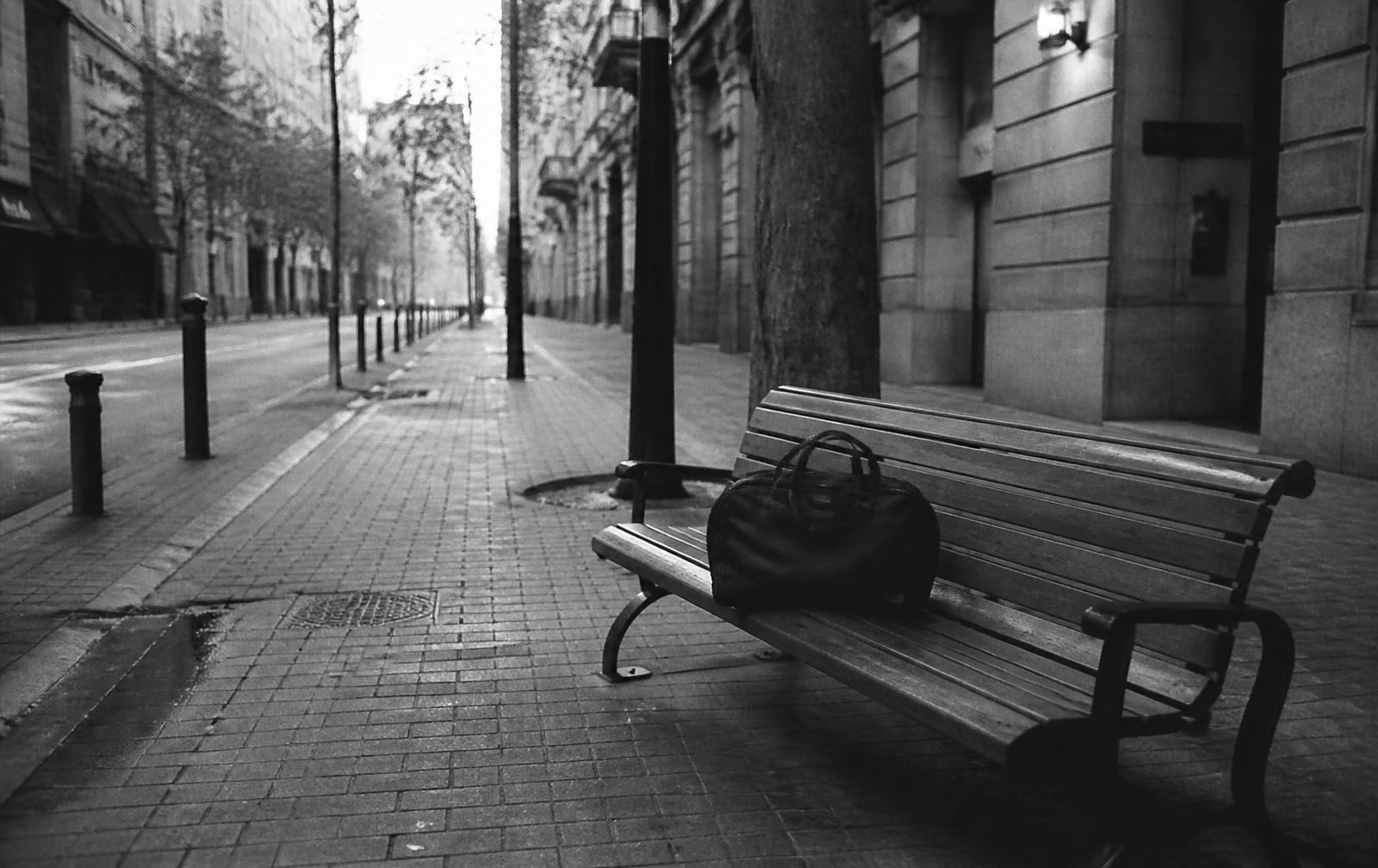 An unattended bag left on a city bench at dawn
